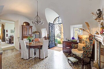 A dining room with a table and chairs and a chandelier