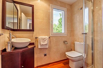 A bathroom with a toilet a sink and a window