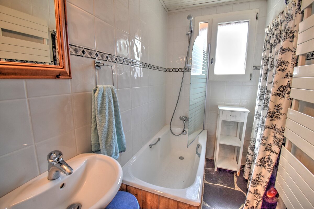 A bathroom with a bathtub a sink and a window