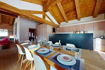 A dining room table with plates and glasses on it