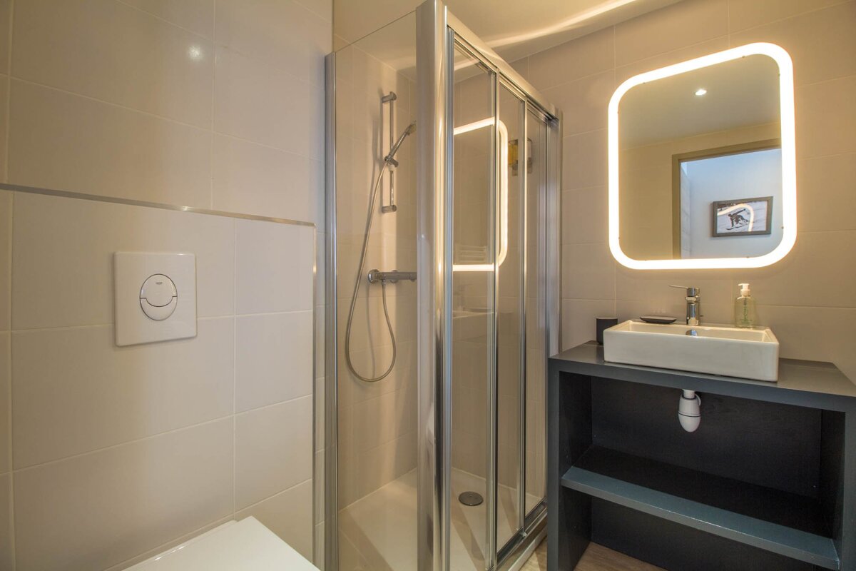 A bathroom with a sink and a shower stall