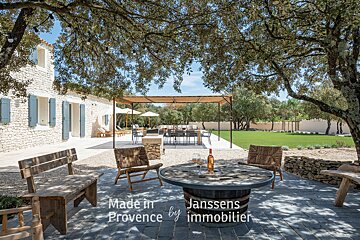 A table with a bottle of wine and a sign that says made in provence by immobilier