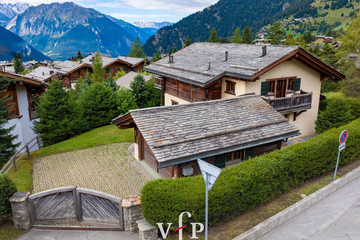 An aerial view of a house with mountains in the background