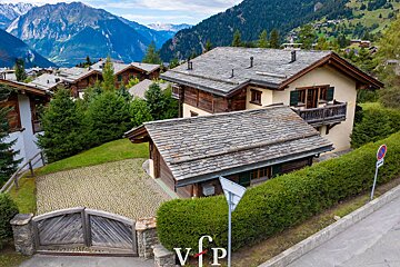 An aerial view of a house with mountains in the background
