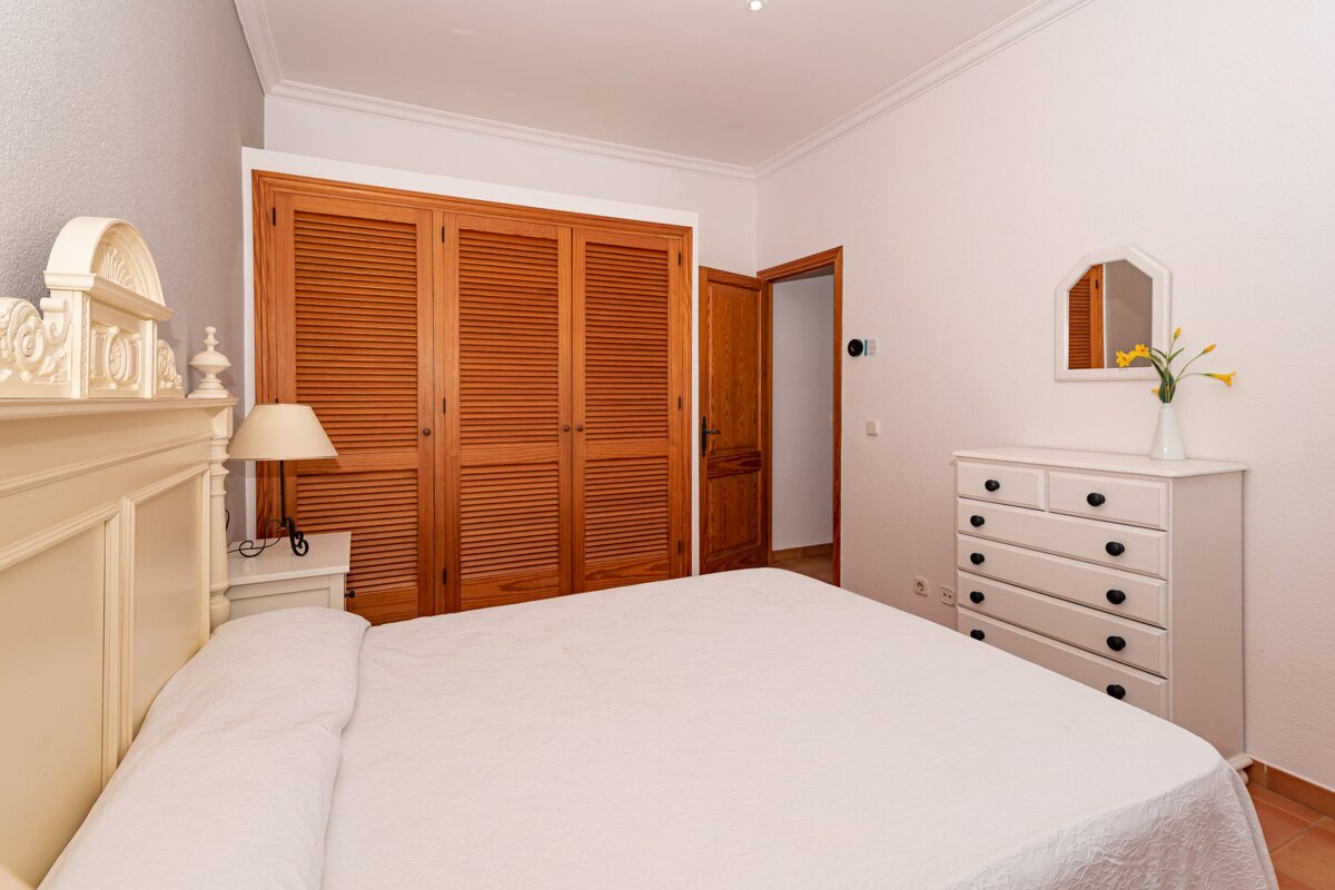 A bedroom with a large bed and a dresser