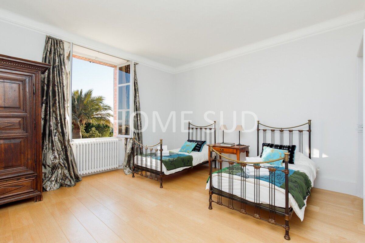 A bedroom with two beds and the word home on the wall