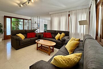 A table with a bottle of wine and a plate of cherries on it