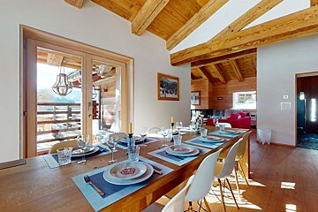 A dining room table with plates and glasses on it