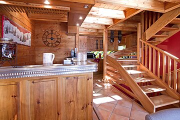 A kitchen with a clock on the wall and a jar that says ' chocolat ' on it