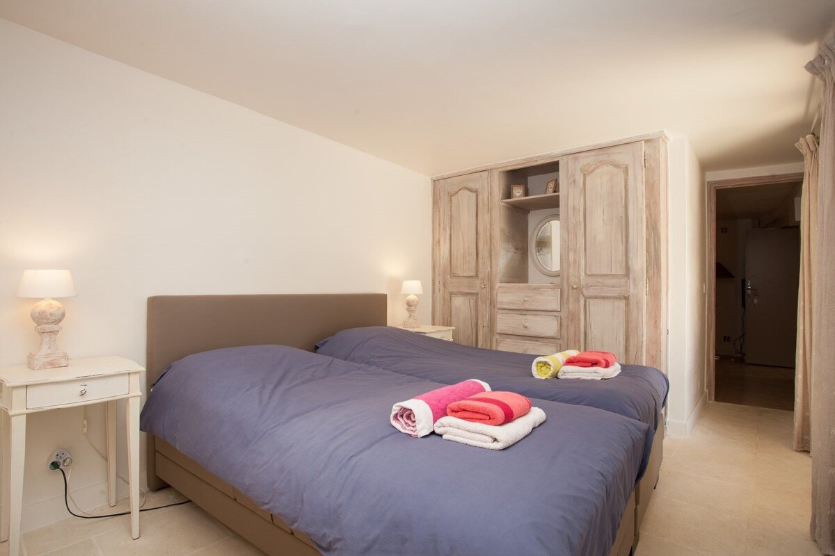 A bedroom with two beds and a wardrobe