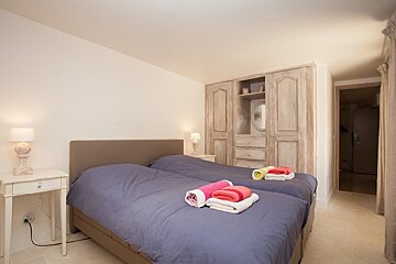 A bedroom with two beds and a wardrobe