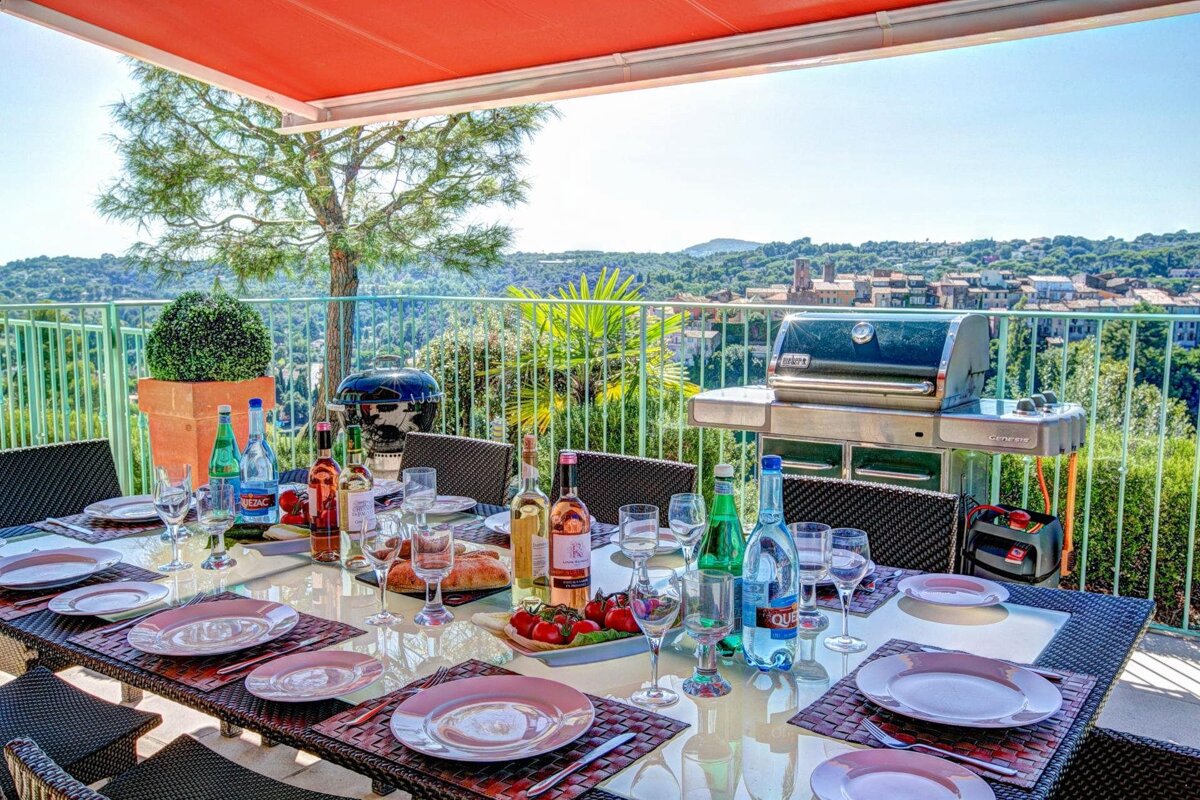 A table set for a meal with a weber grill in the background