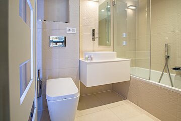 A bathroom with a toilet a sink and a bathtub