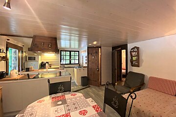 A kitchen with a table and chairs and a sign that says ' cafe ' on it