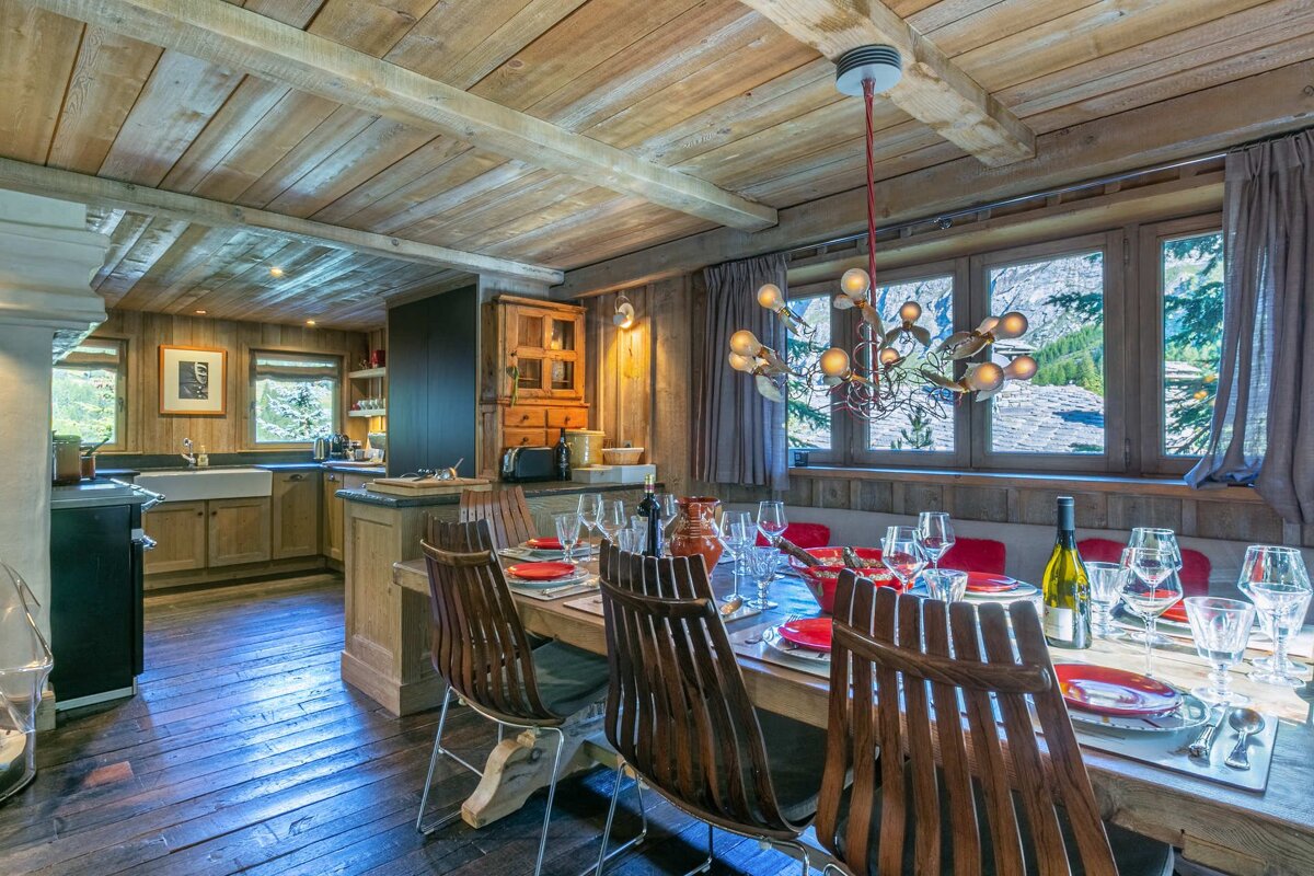 A dining room table with a bottle of wine on it