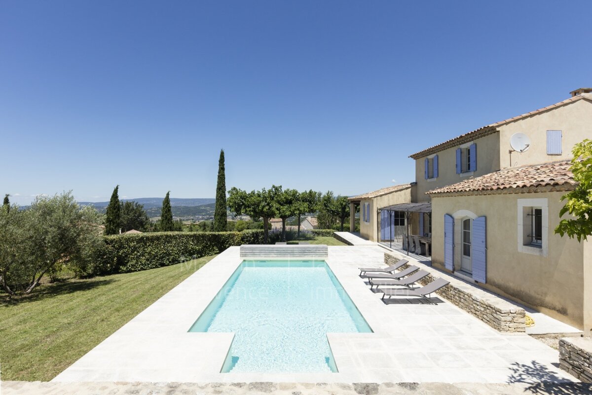 A large house with a swimming pool in front of it
