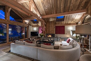 A living room with a curved couch and a fireplace