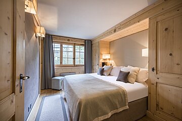 A bedroom with a large bed and a window