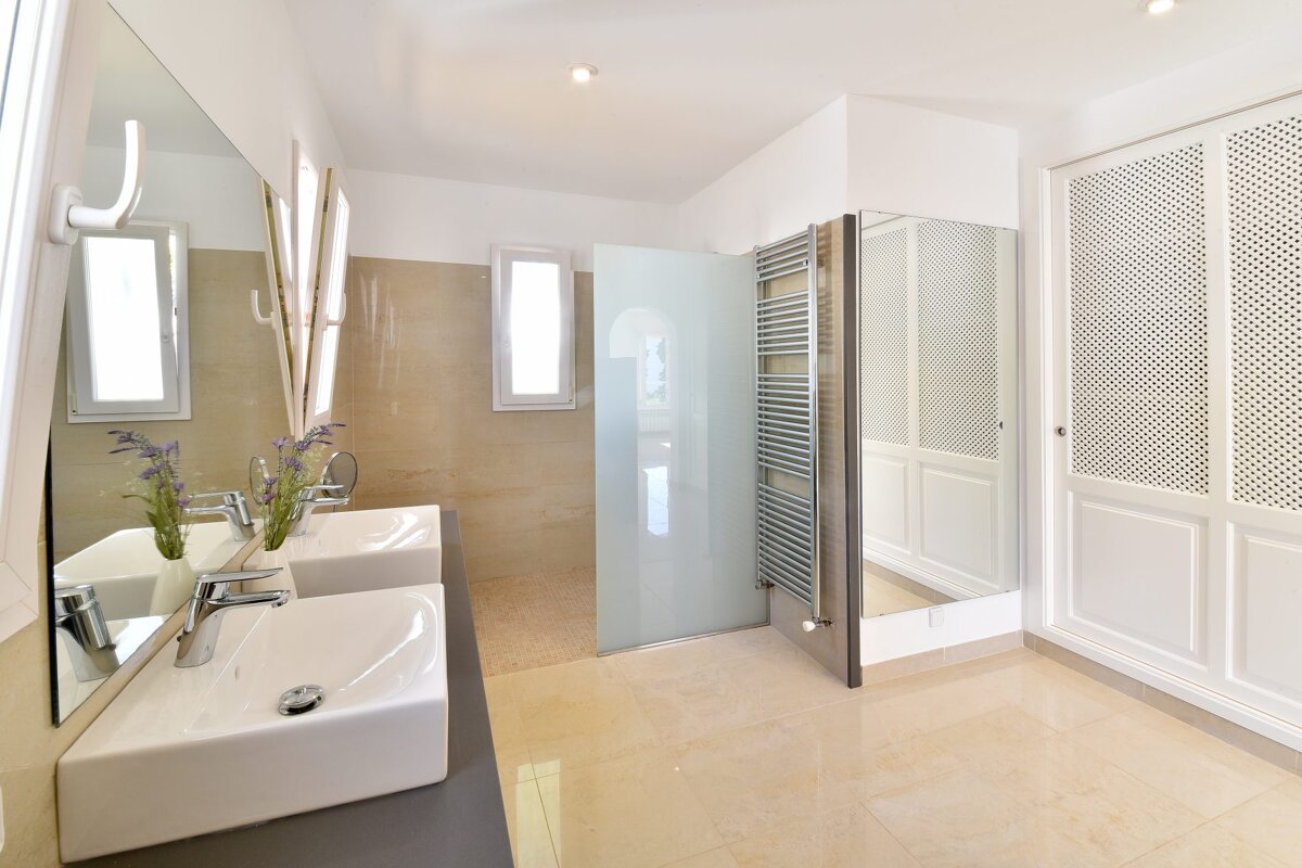 A bathroom with two sinks and a walk in shower