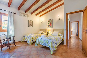 A bedroom with two twin beds and a chair