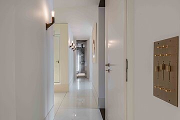 A long hallway with a light on the wall