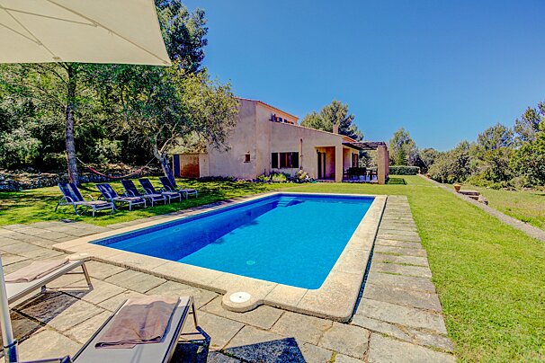 A large swimming pool with a house in the background