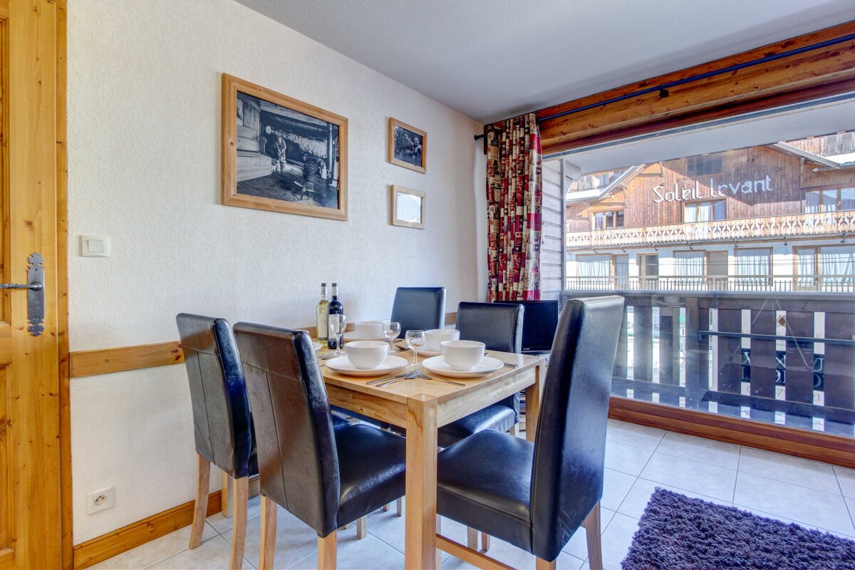 A dining room with a table and chairs and a sign that says soleil levant