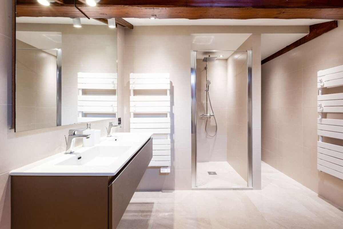 A bathroom with two sinks and a walk in shower