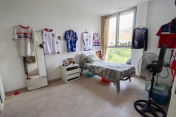 A bedroom with jerseys hanging on the wall including one that says pepsi