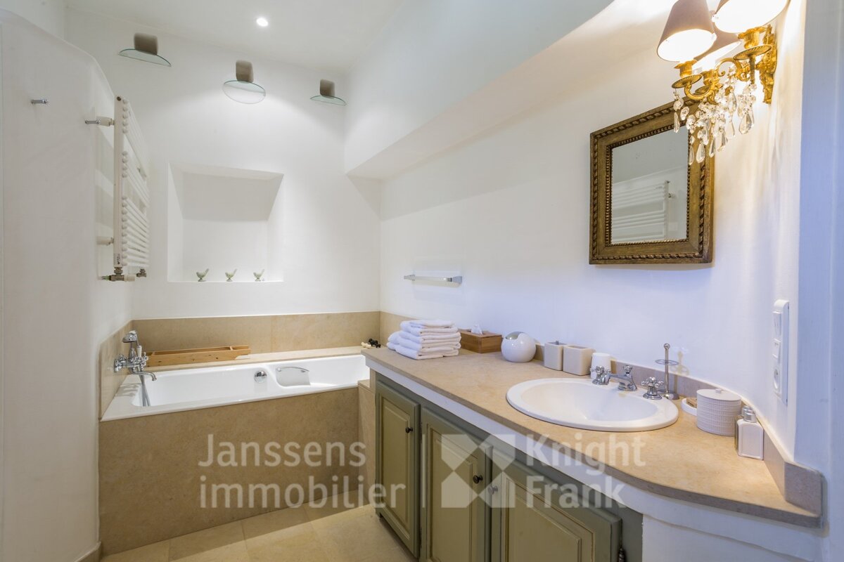 A bathroom with a sink and a bathtub with janssens immobilier written on the counter