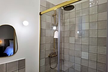 A bathroom with a shower and a mirror