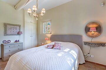 A bedroom with a bed a dresser and a mirror