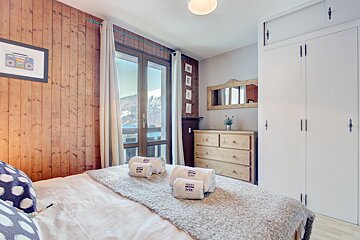 A bedroom with a bed and a dresser and a picture of a radio on the wall