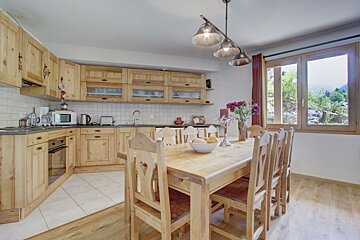 A kitchen with wooden cabinets and a dining table