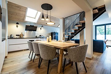 A dining room with a wooden table and chairs