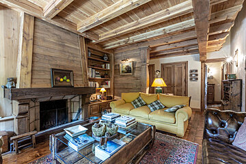 A living room with a yellow couch and a fireplace