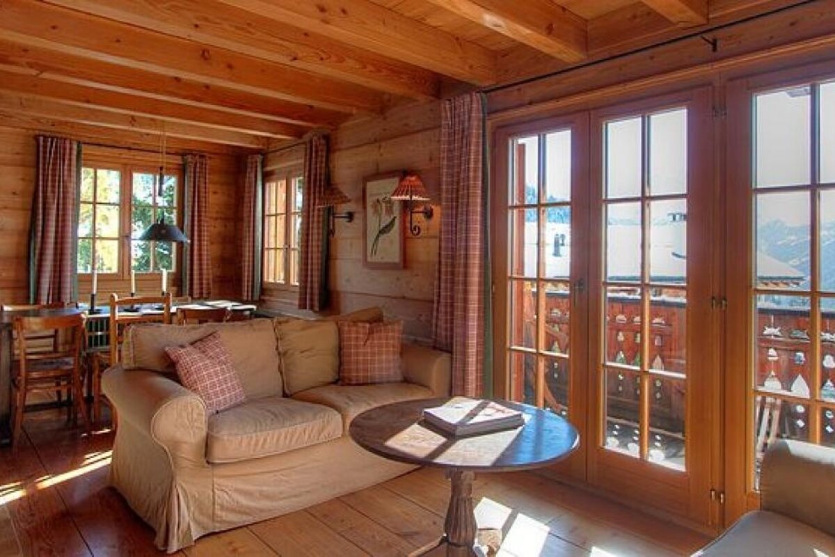 A living room in a log cabin with a couch and a table