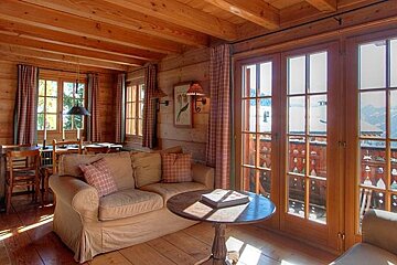 A living room in a log cabin with a couch and a table