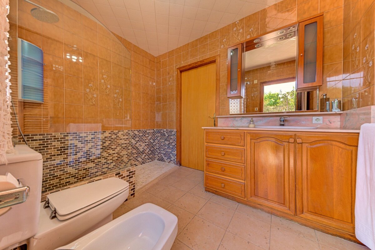 A bathroom with a toilet a sink and a mirror