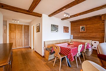 A dining room table with a red and white polka dot tablecloth