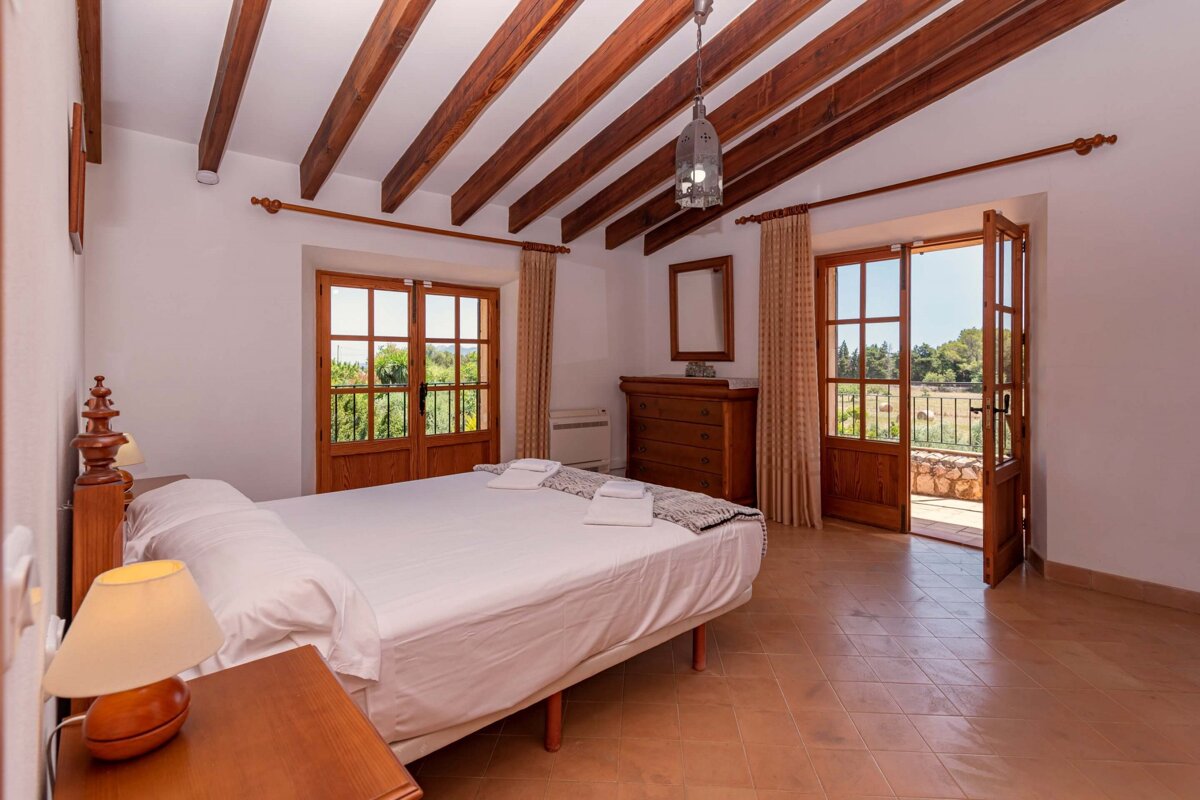 A bedroom with a large bed and a balcony