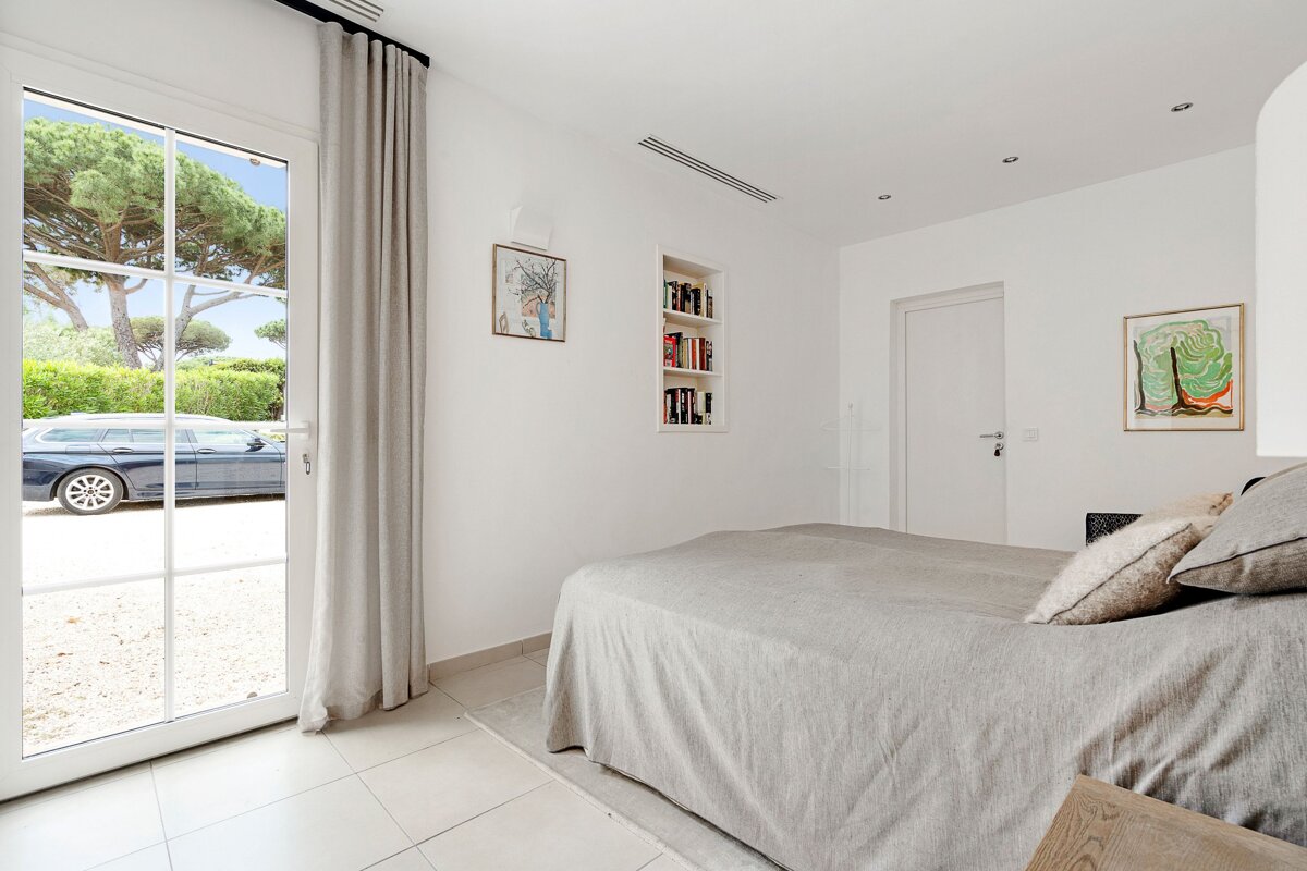 A bedroom with a bed and a sliding glass door
