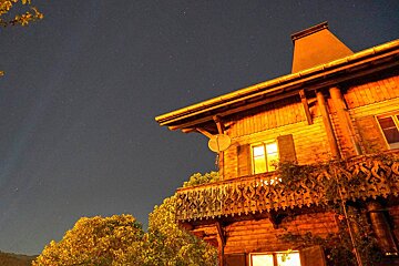 A house with a balcony is lit up at night