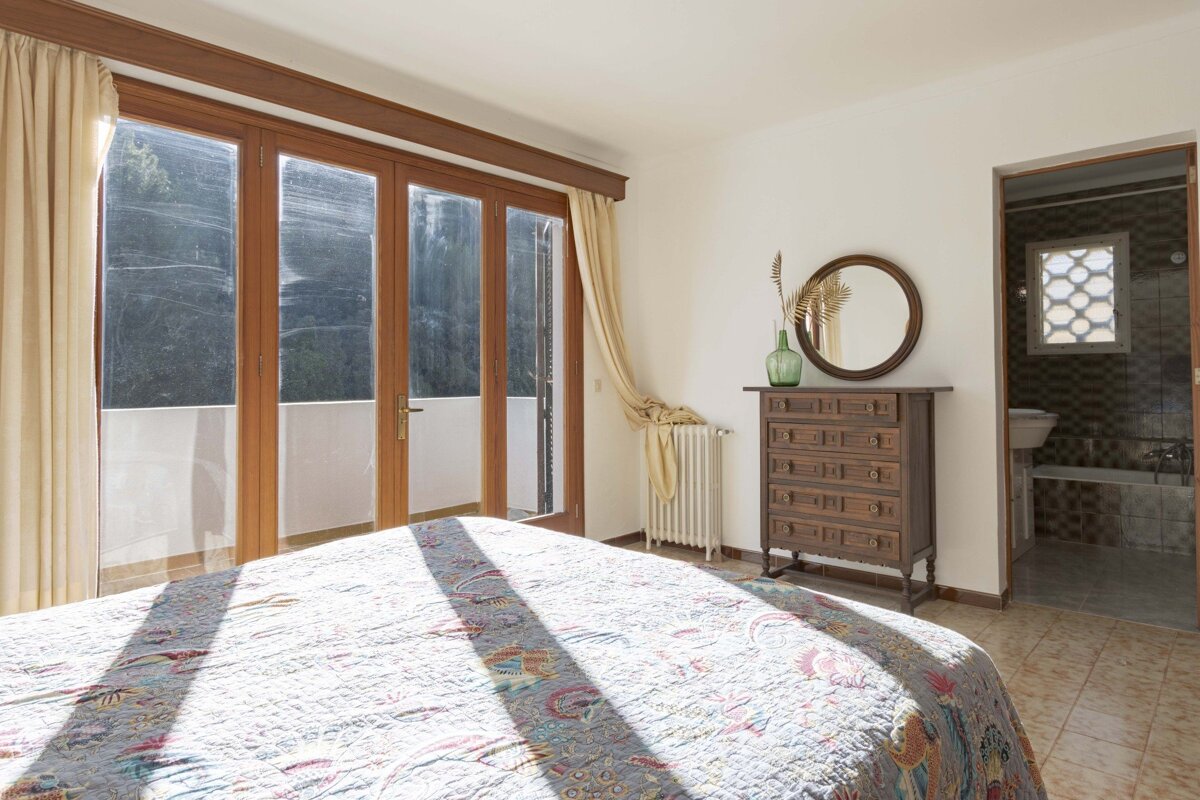 A bedroom with a dresser and a mirror