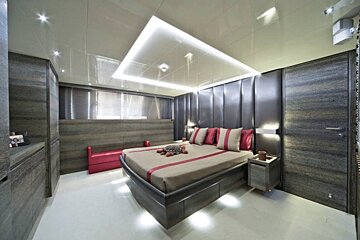 A bedroom with a large bed and red and white pillows