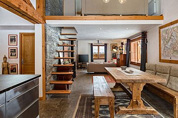A living room with a wooden table and stairs