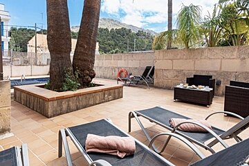 A patio area with lounge chairs and a table