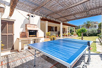 Ping pong tables under a canopy in front of a house