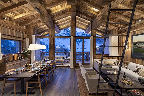 A living room with a ladder leading up to the second floor