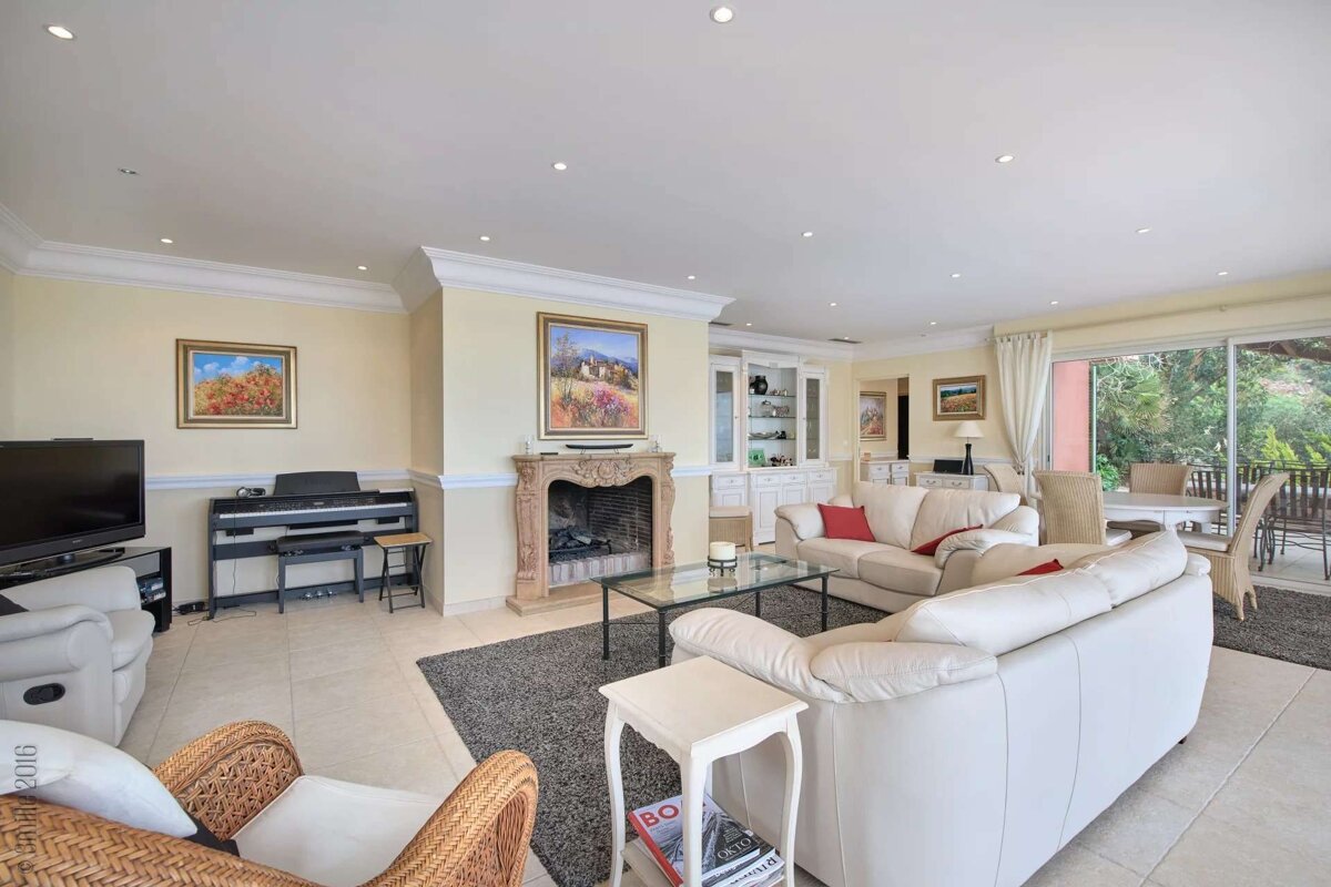 A living room with white furniture and a fireplace